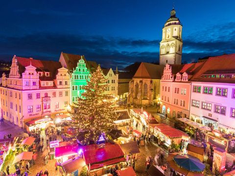 Auf dem Meißner Markt stehen Buden vom Weihnachtsmarkt. Daneben erhebt sich der Turm der Frauenkirche. 