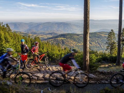 Biker fahren im Trail Park in Klinovec mit Blick auf den Egergraben und auf das Duppauer Gebirge