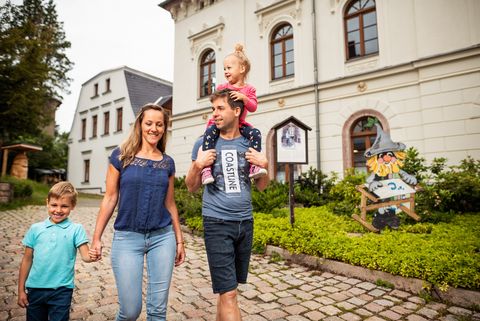 Eine Familie spaziert durch Eibenstock in Sachsen im Erzgebirge. Die Mutter hat einen Jungen an der Hand, der Vater ein Mädchen auf den Schultern. 