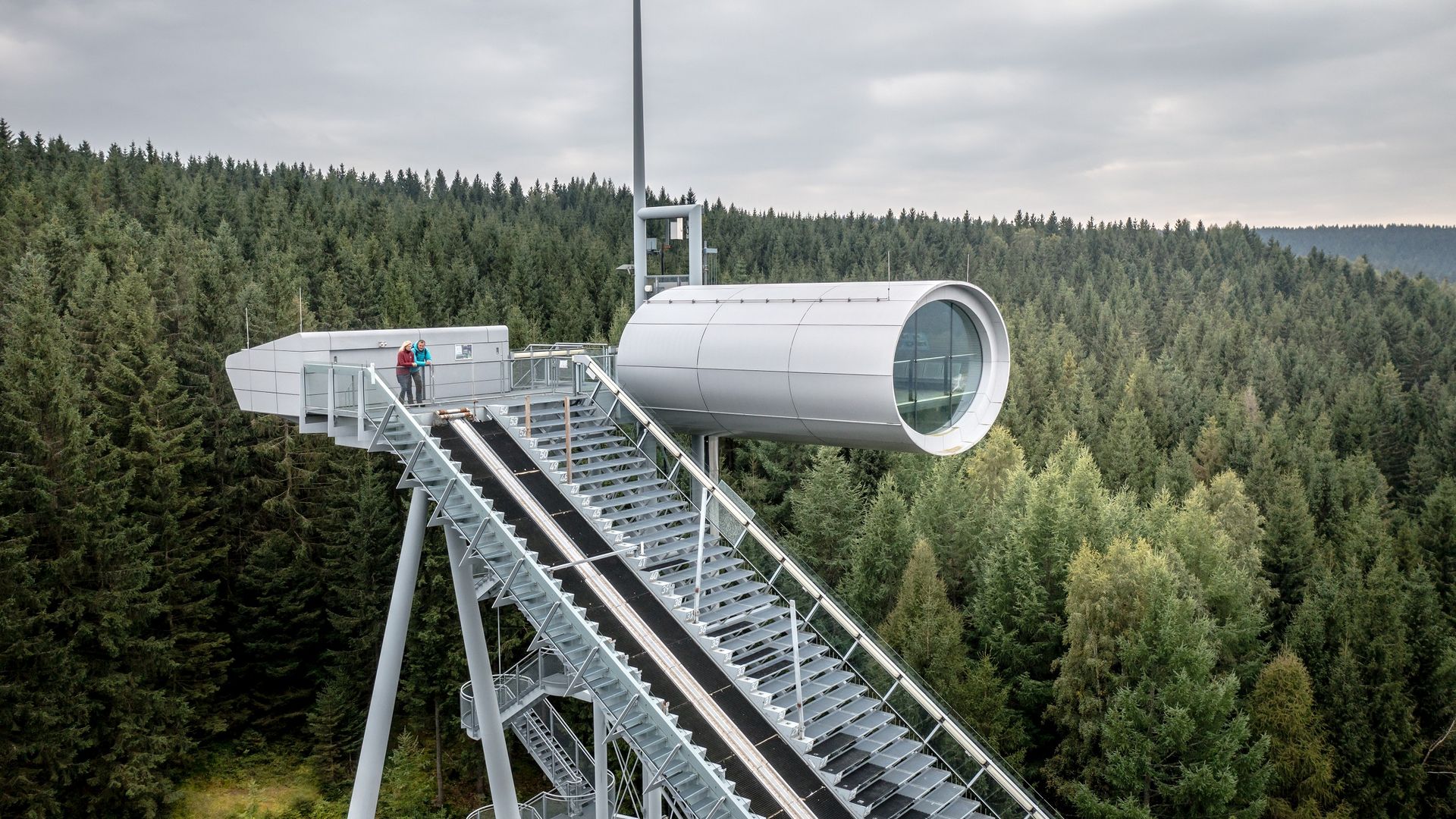 Blick auf die Skisprungschanze der Sparkassen Vogtland Arena mit Aussichtskapsel.